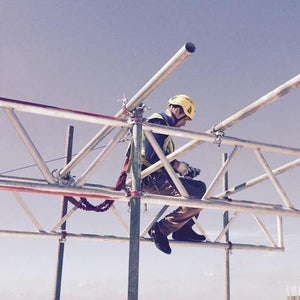 Scaffolder working at height using height safety equipment