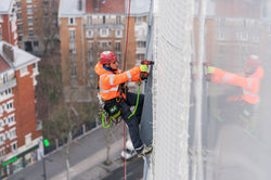 Worker using NLG tool safety products at height